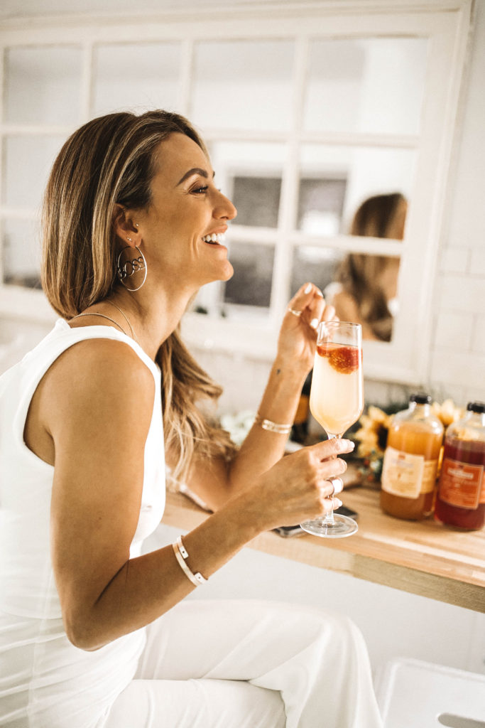 drinking a peach bellini  - Spring Essentials: Lulus Dresses, Shorts, Top and Jumpsuit featured by popular Indianapolis fashion blogger, Karina Style Diaries