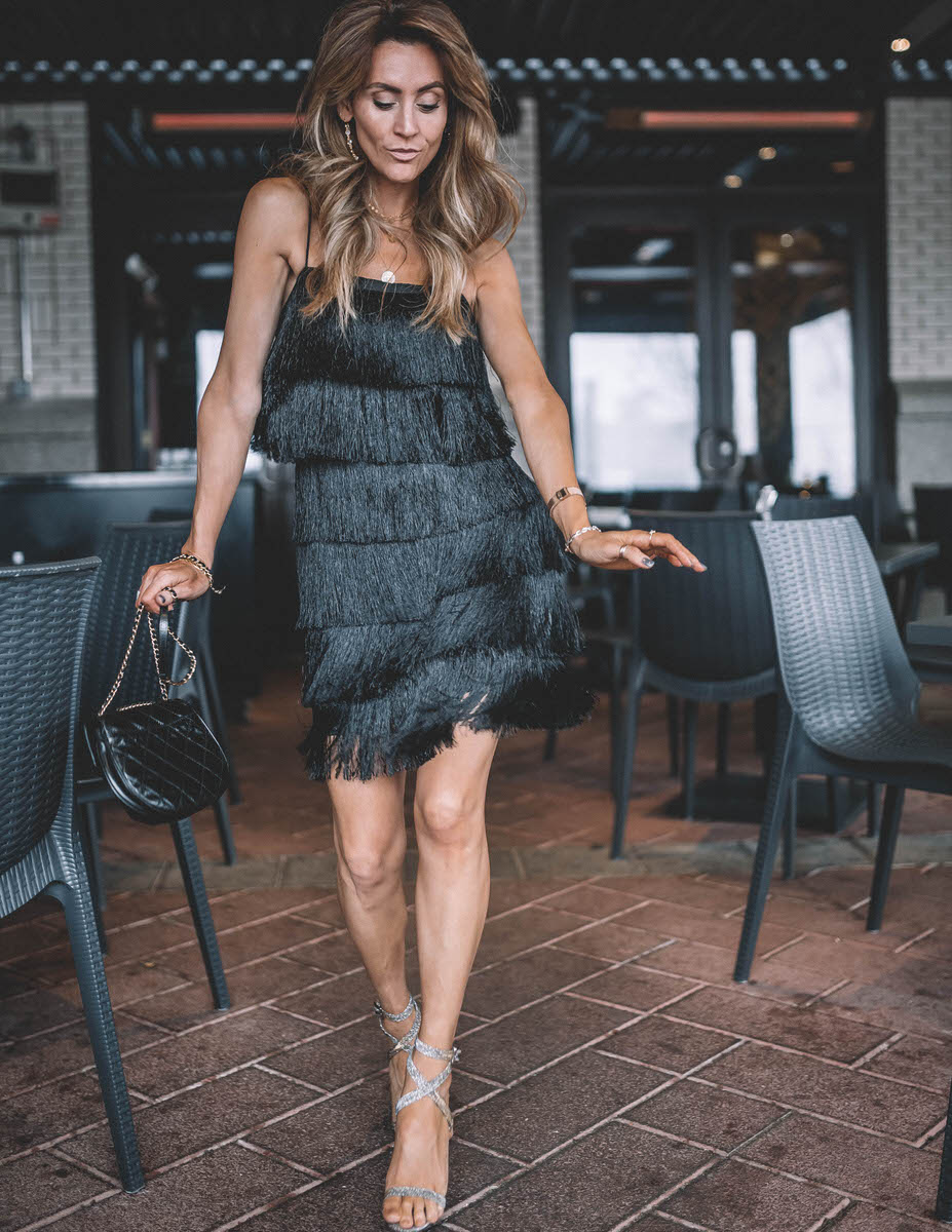 Holiday Party look featured by top Indianapolis fashion blogger, Karina Style Diaries: image of a woman wearing a Lesley Jane black fringe dress, Manolo Blahnik heels, Chanel bubble bag, Daniel Wellington watch and Jemma Sands drop earrings