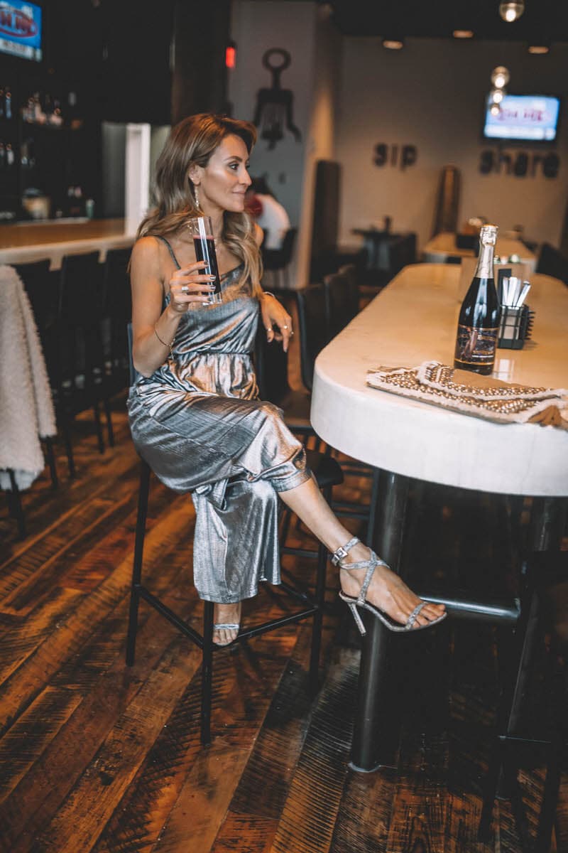 Top Indianapolis fashion blogger, Karina Style Diaries, features the perfect Holiday look with a BB Dakota metallic Jumpsuit: image of a blonde woman wearing a BB Dakota metallic jumpsuit, a BB Dakota faux fur coat, a Sashi clutch and Manolo Blahnik silver heels