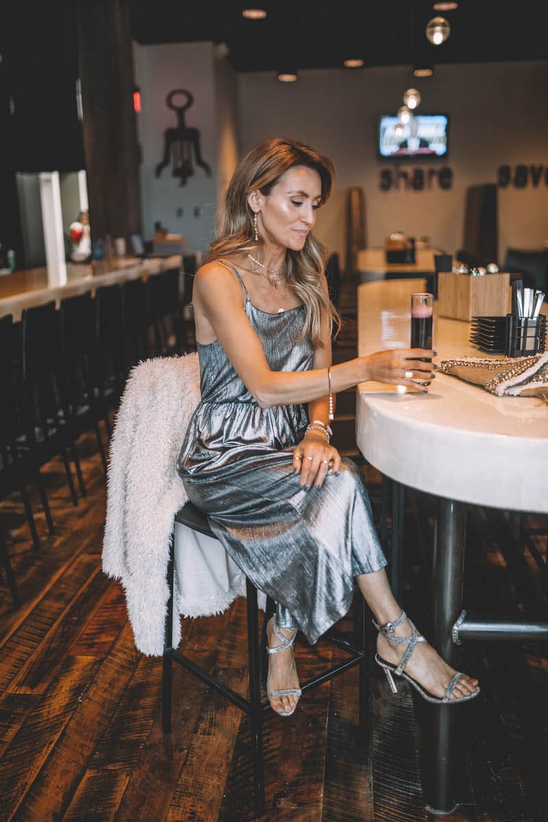 Top Indianapolis fashion blogger, Karina Style Diaries, features the perfect Holiday look with a BB Dakota metallic Jumpsuit: image of a blonde woman wearing a BB Dakota metallic jumpsuit, a BB Dakota faux fur coat, a Sashi clutch and Manolo Blahnik silver heels