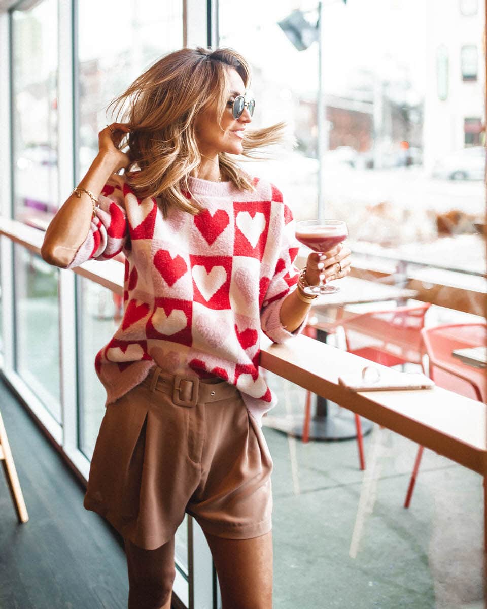 Fashion Blogger Karina Reske| Heart Pattern sweater | Valentine's day outfit | cute bar photos | Goodnight Macaroon Valentines Day sweater featured by top US fashion blogger, Karina Style Diaries: image of a woman wearing a Valentines Day sweater, Romwe shorts, Steve Madden toe pumps, Givenchy Antigona, and Ray-Ban aviator sunglasses
