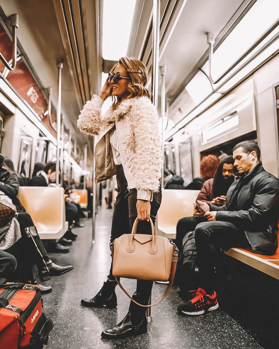 Fashion Blogger Karina Reske | NYC Subway | Gucci barrette | Leather leggings | studded flat booties | givenchy antigona old pink small NYFW outfits and tips featured by top US fashion blogger, Karina Style Diaries: image of a woman wearing a BlankNyc faux fur bomber jacket, SPRWMN leggings, Mango satin shirt, Rebecca Minkoff Chelsea boots, Gucci bag, sunglasses and barrette