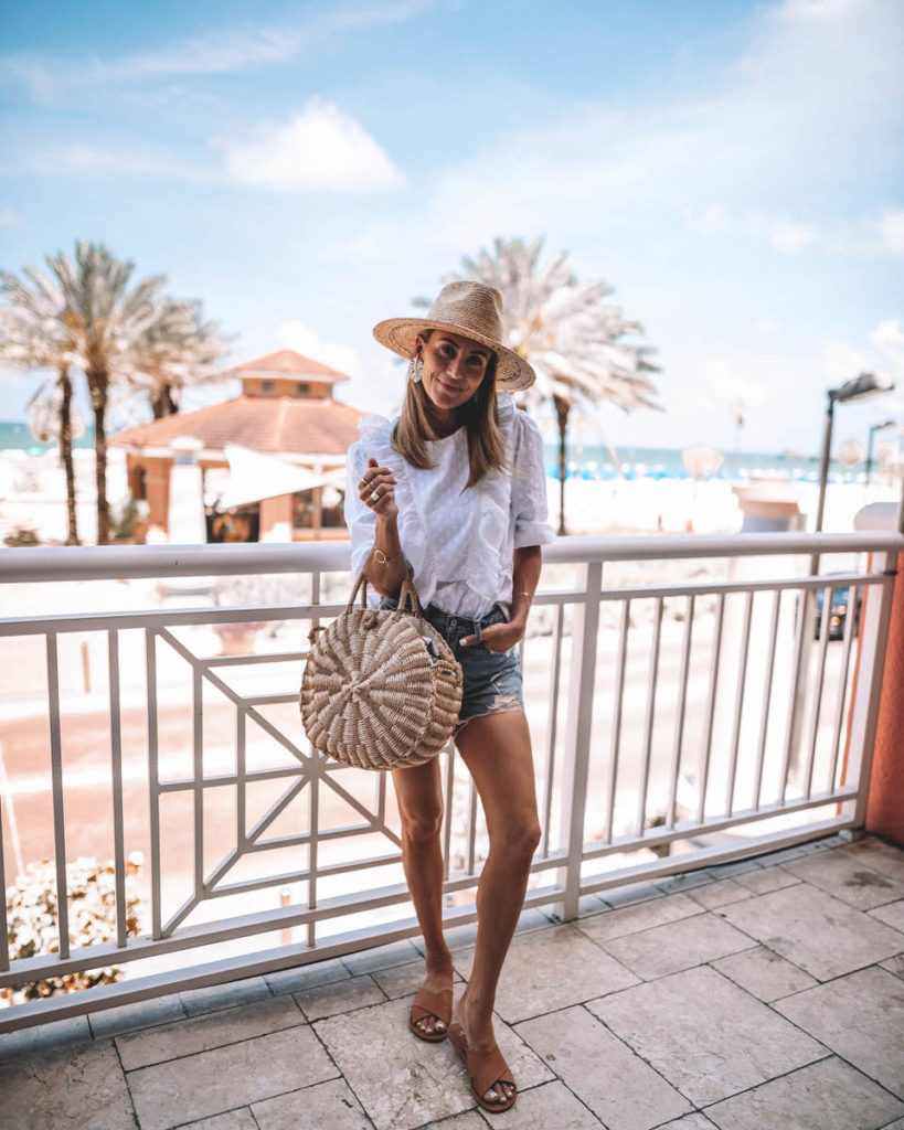 Travel Blogger Karina Style Diaries | white eyelet top | high waist destroyed shorts | round basket bag | Bixton straw hat | bauble bar white leaf earring