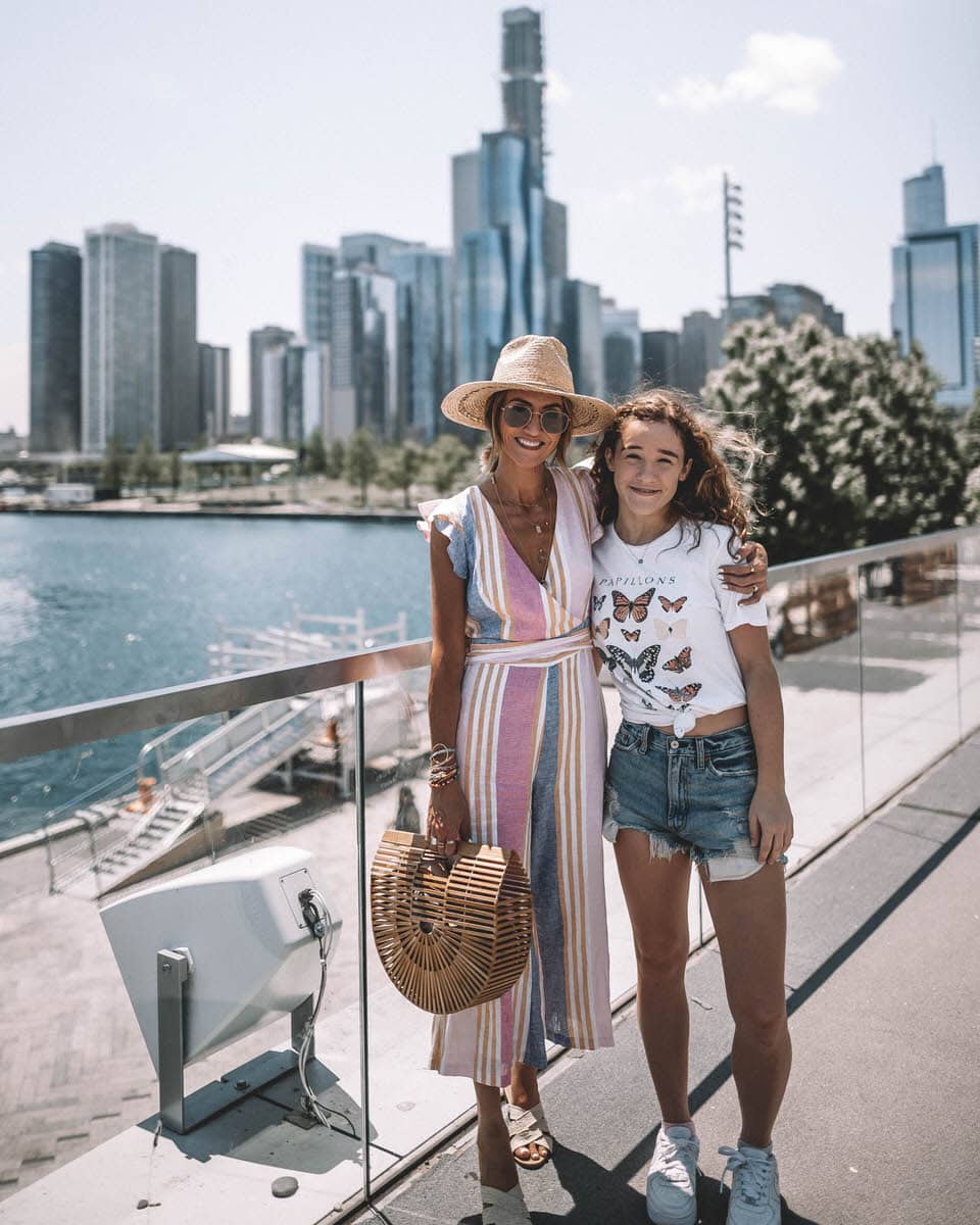 Karina Style Diaries and Isabella Reske wears striped colorful jumpsuit with ruffle on the sleeves and cropped pant straw hat bamboo bag navy pier chicago