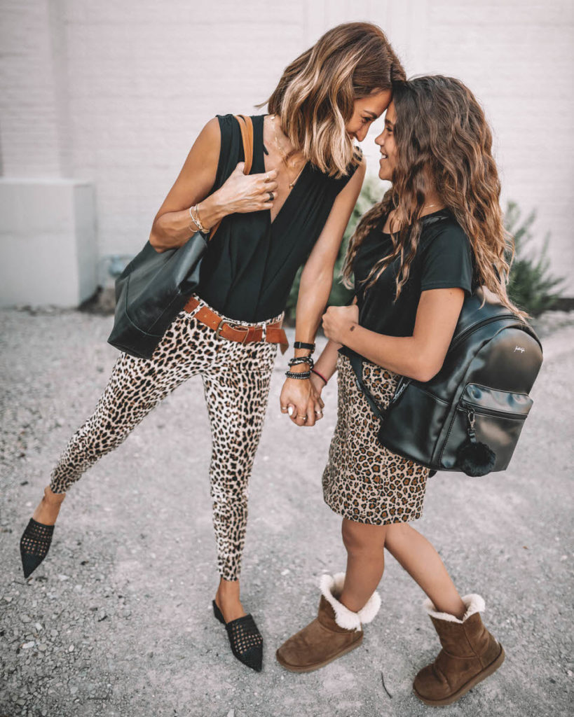 Karina Reske and daughter Sophia back to school mommy and me outfit ideas leo print pants and skirt black top black backpack uggs