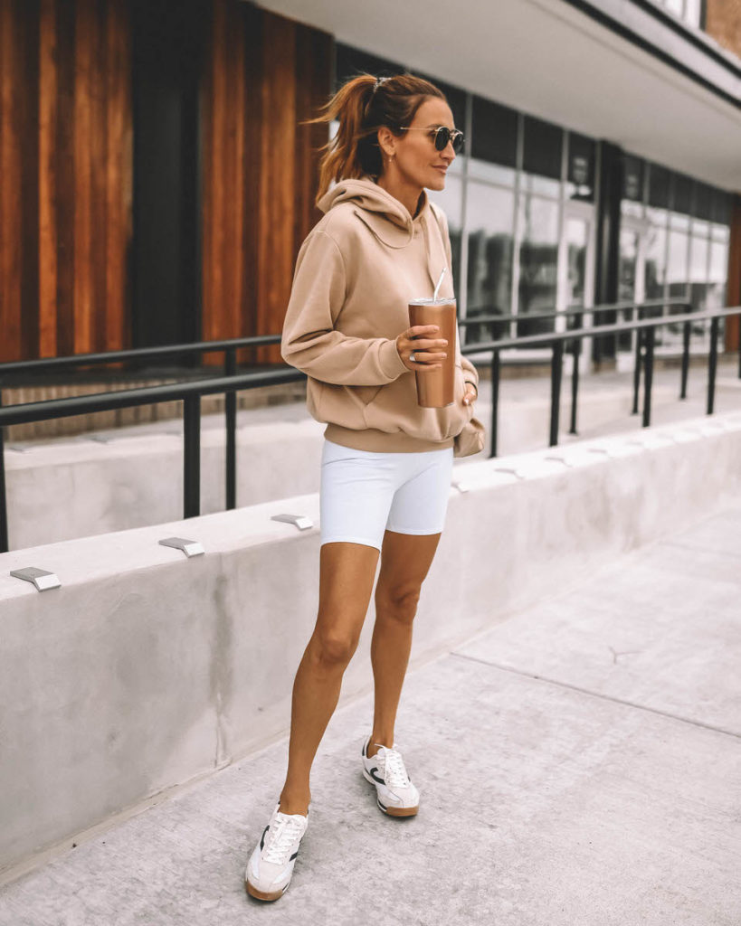 Karina Style Diaries at home workouts post wearing white niker shorts tan hoodie 