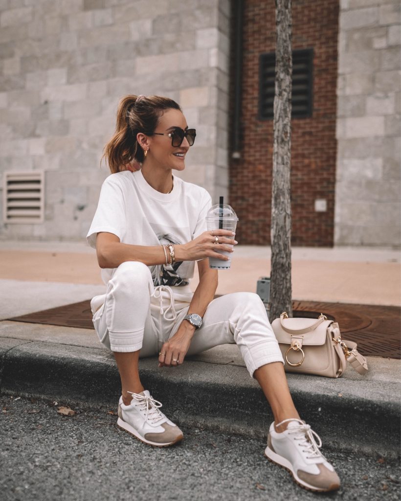 Karina wears tory burch sneakers with white joggers and graphic tee