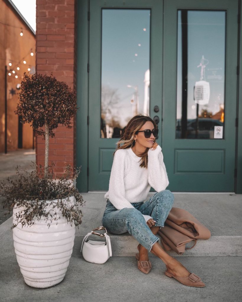 Karina wears express camel wrap coat with white sweater and straight ankle jeans