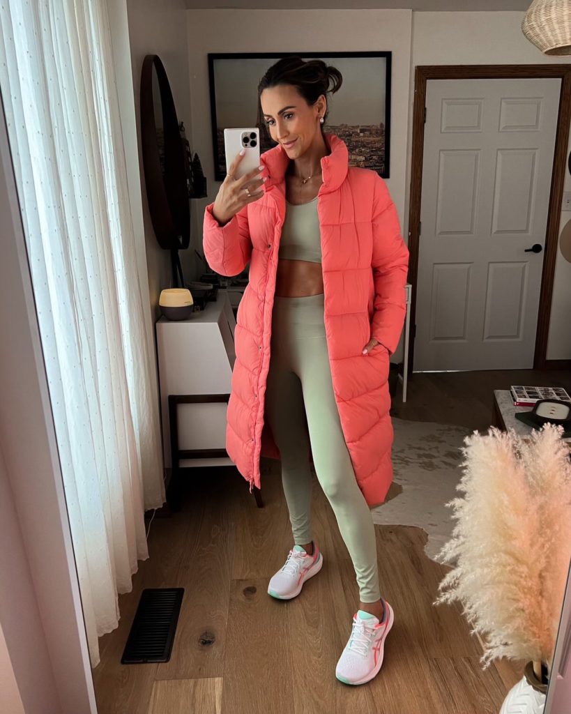 karina wears green amazon workout set with pink puffer coat and asics sneakers