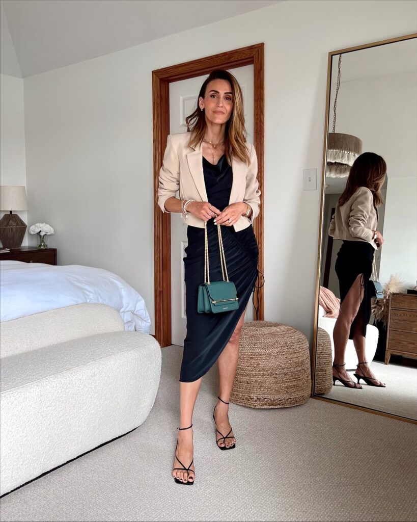 Karina wears abercrombie black cinched dress with cropped blazer and strathberry handbag