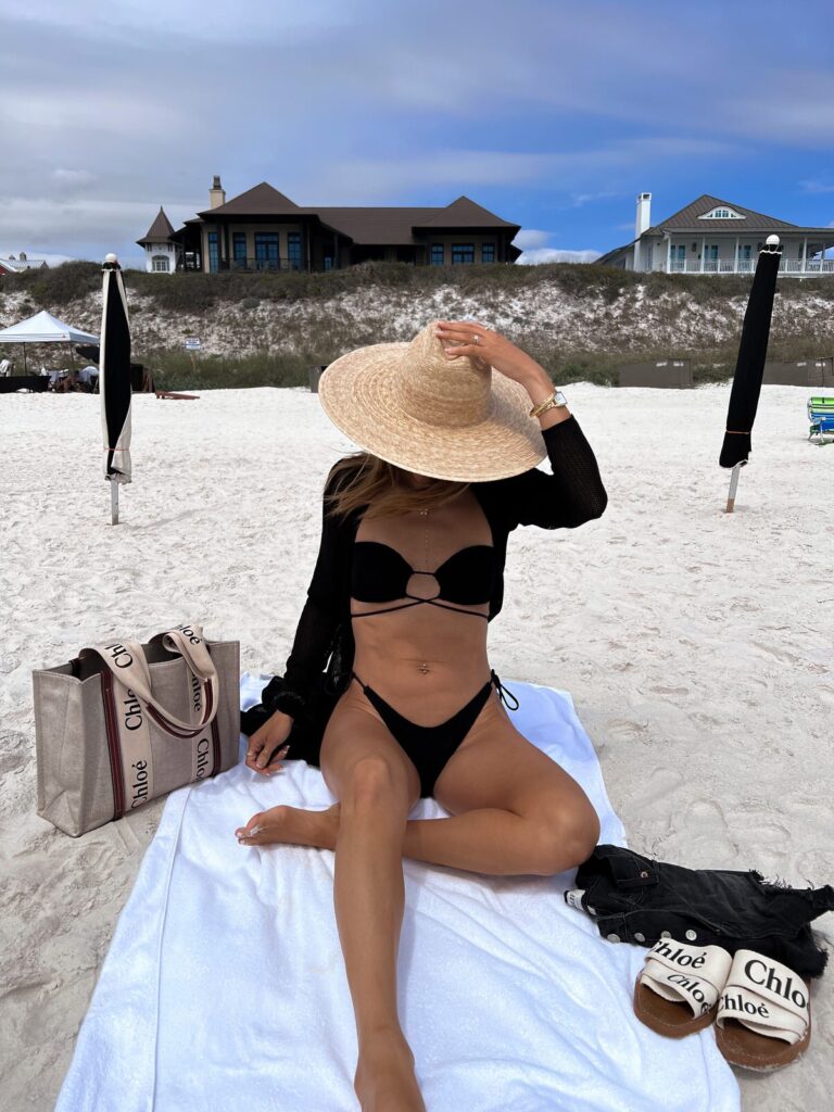 Karina wears bond eye black bikini with chloe tote and slides and sun hat