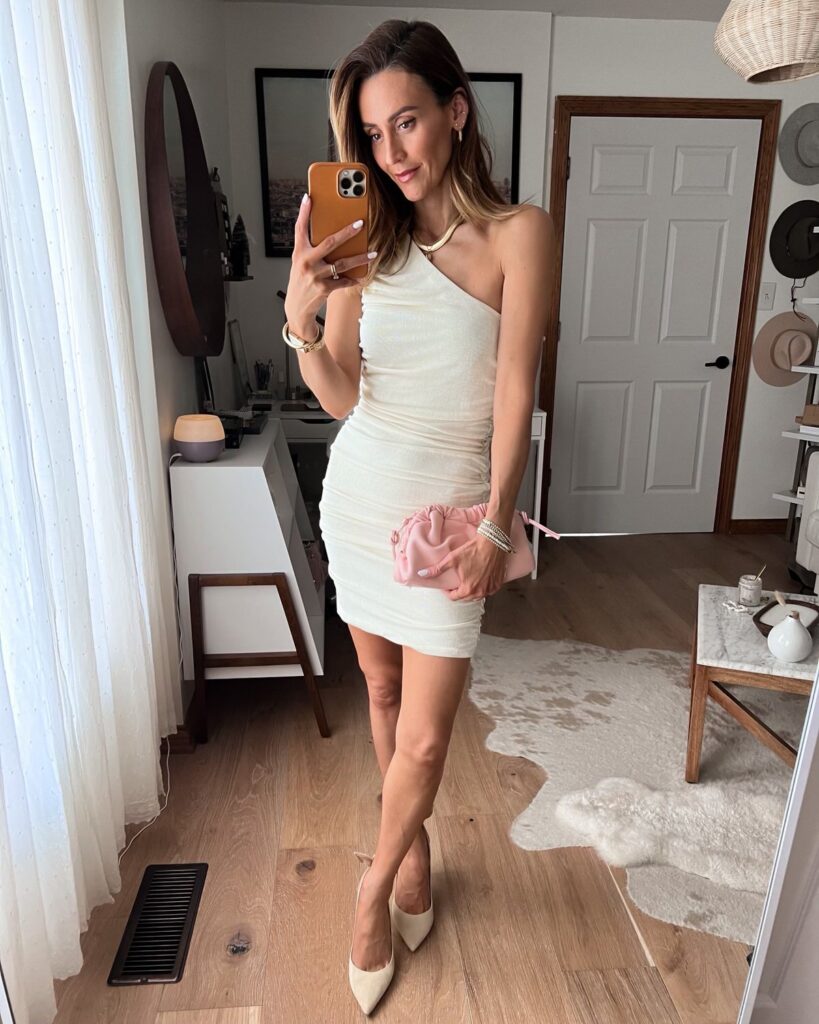 Karina wears amazon cream ruched one shoulder body con dress with nude pumps and dumpling bag