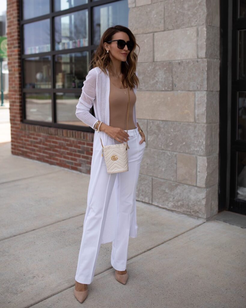 karina wears express white trousers with tan tank top and white duster with gucci bucket bag