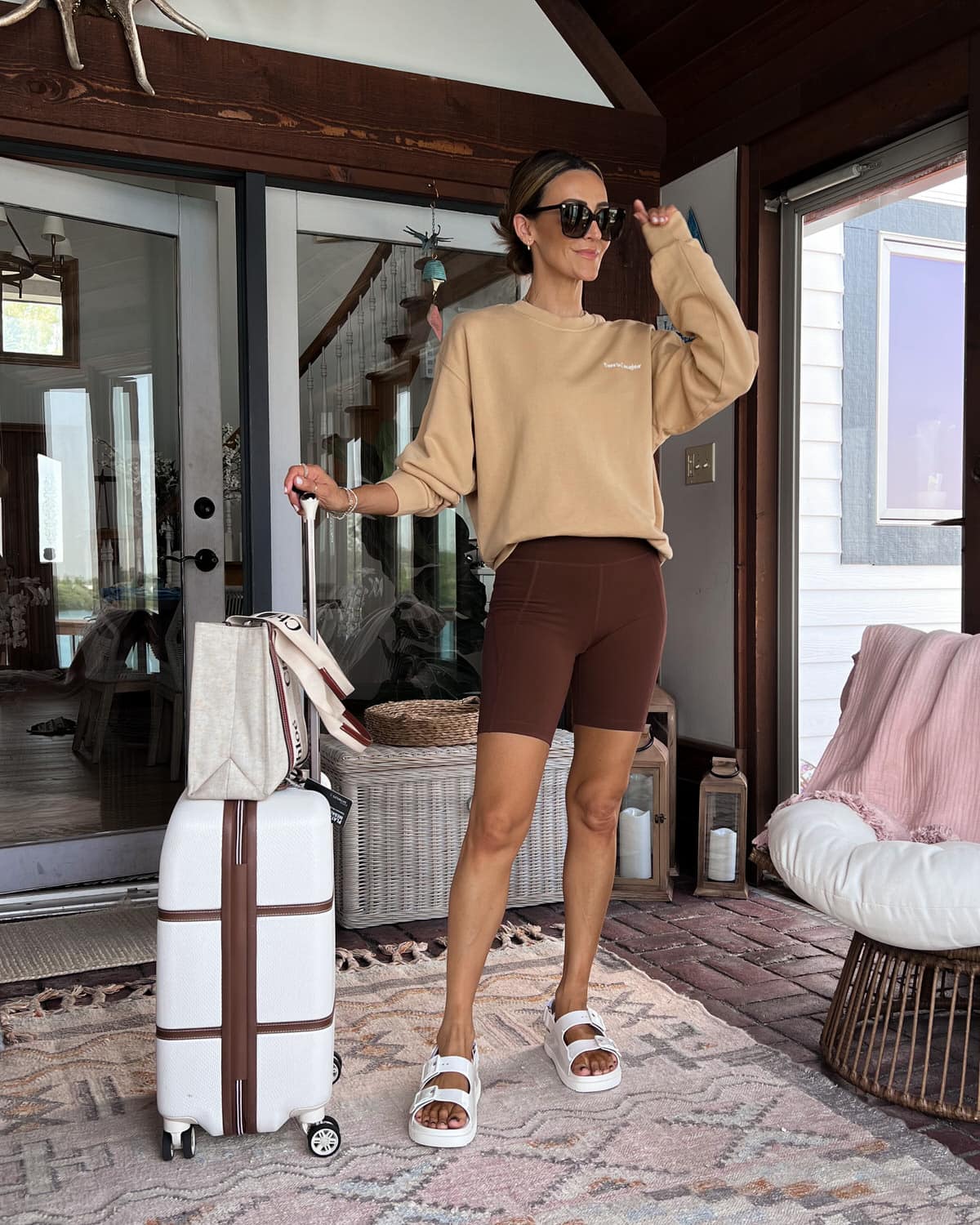 karina wears brown girlfriend biker shorts with tan sweatshirt and chloe tote bag