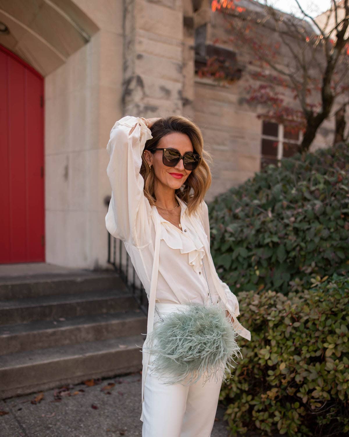 Karina wears agolde white leather pants with white top and feather bag