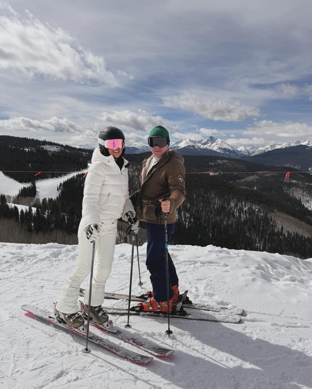 ski trip outfit - white ski pants with a matching puffer jacket, ski gloves, a ski helmet, and ski goggles