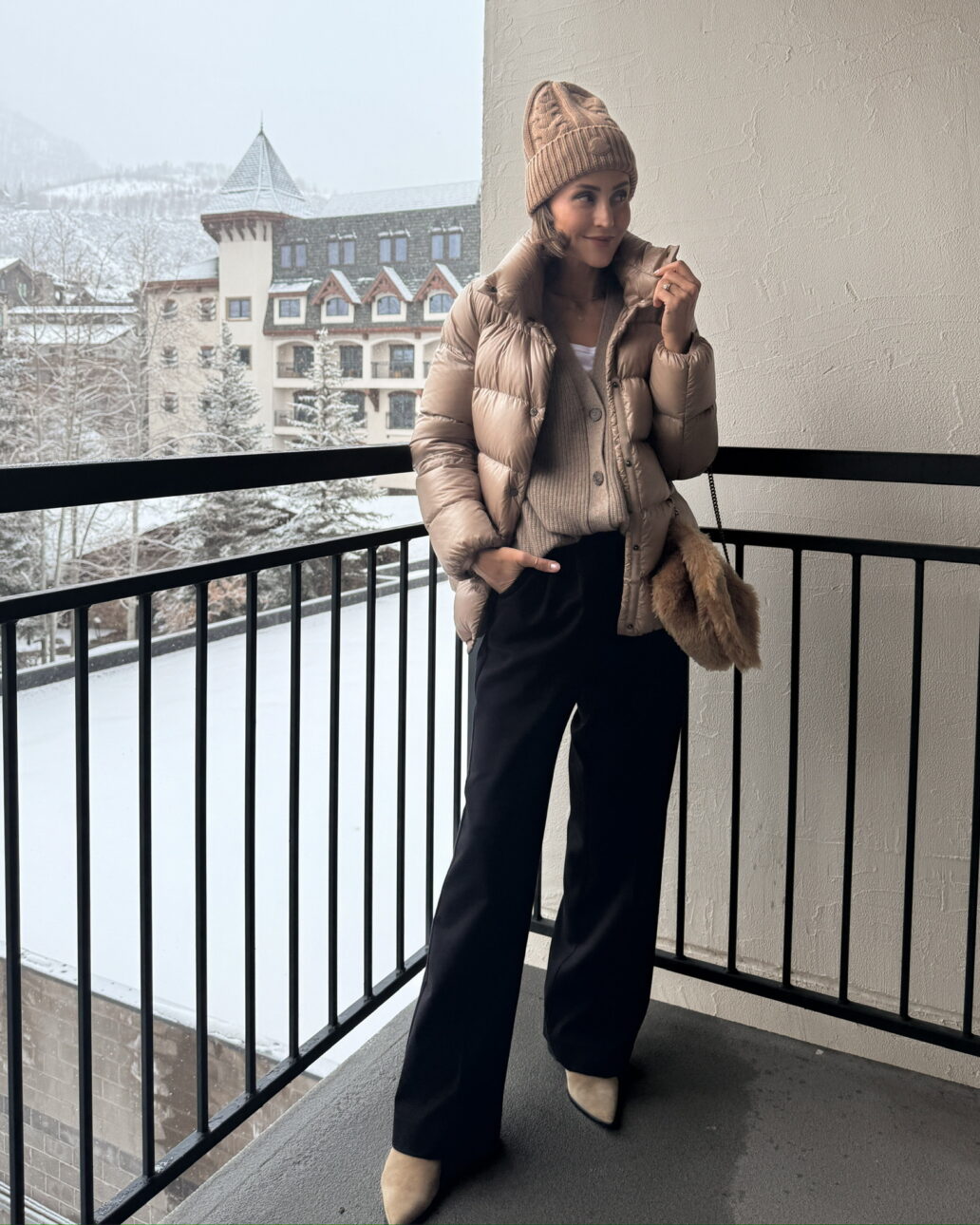 ski trip outfit for a night out - black wide leg trousers with a button down cardigan, puffer jacket, beanie, and suede booties