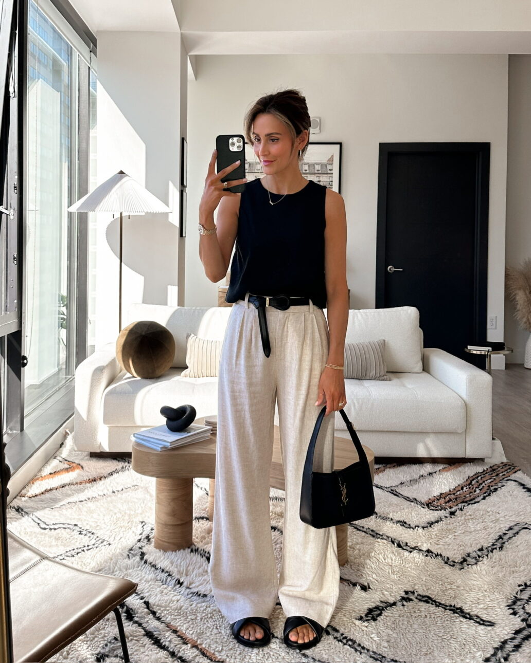 linen trouser outfit with a black tank top, black leather belt, and matching black sandals