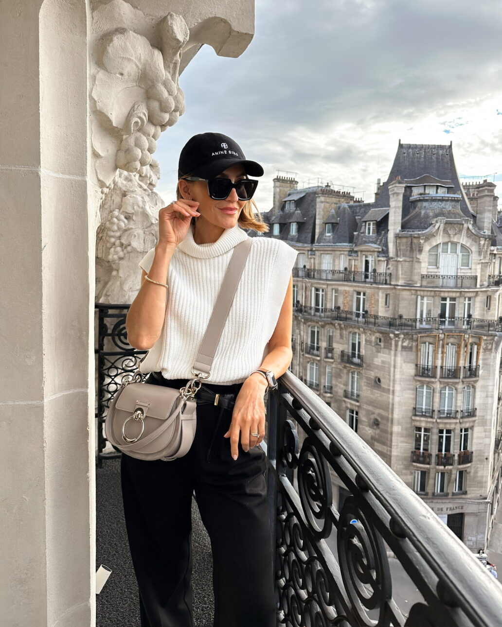 what to wear while shopping in Paris - sweater tank with black cargo pants and a baseball cap